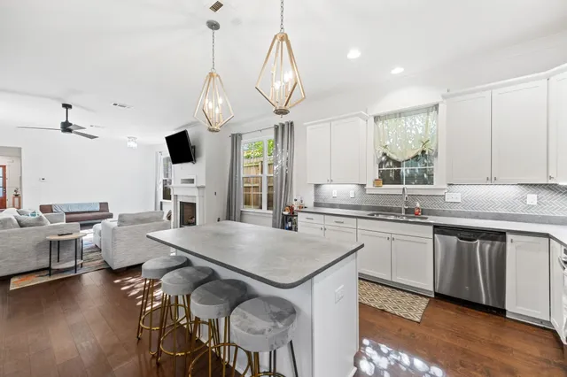 a kitchen with center island stainless steel appliances a table chairs sink and stove top oven