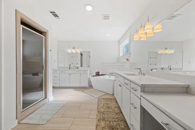 a bedroom with a large bed and a chandelier