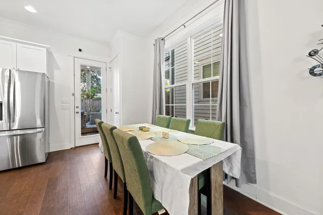a kitchen with stainless steel appliances a dining table chairs and a refrigerator