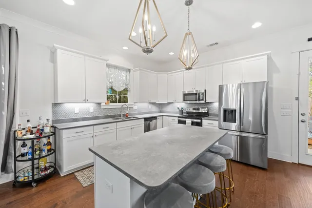 a kitchen with granite countertop a center island stainless steel appliances cabinets and wooden floor