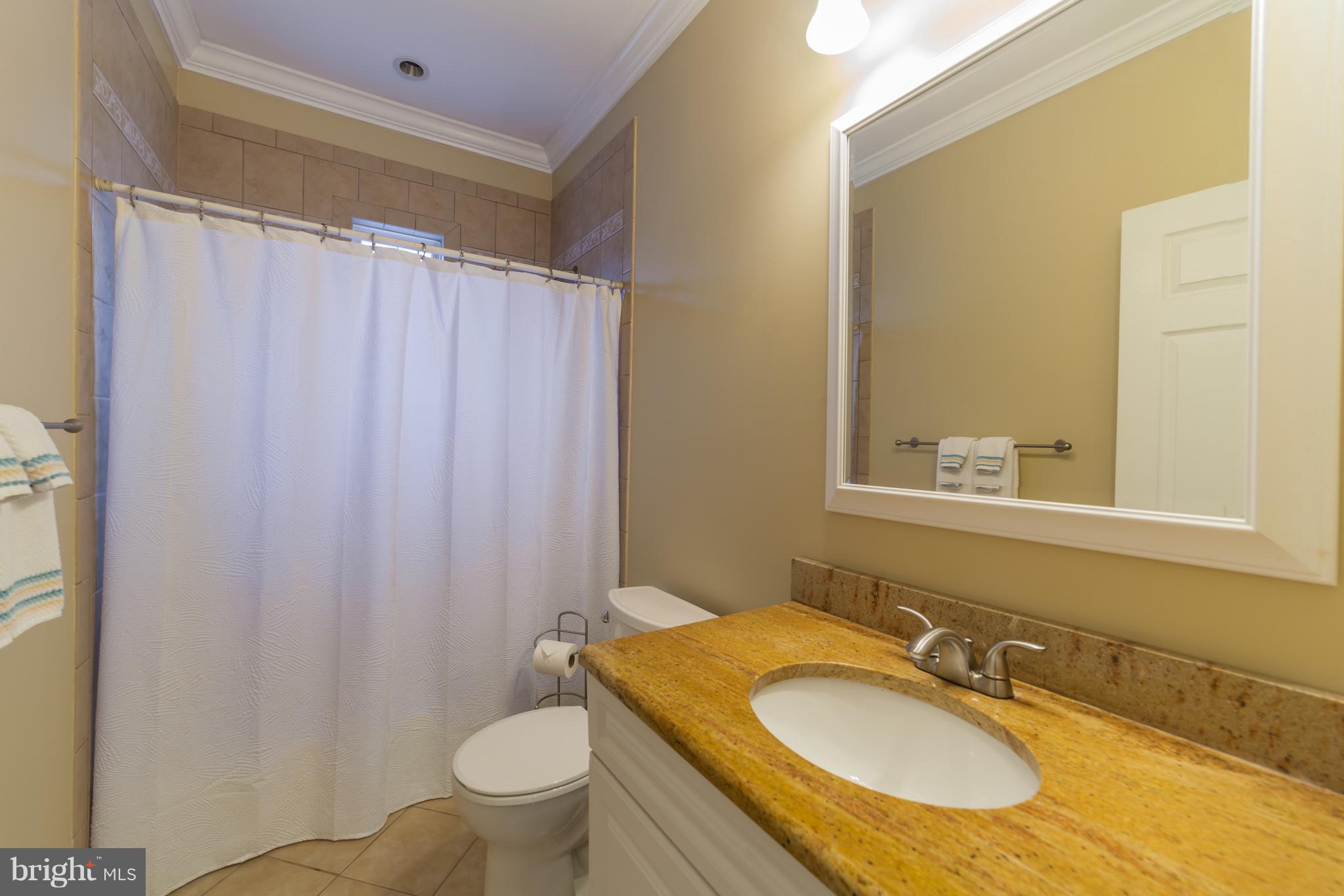 11704 Goodloe Road Silver Spring, MD 20906 - Photo 28 of 30 a bathroom with a granite countertop sink toilet and a mirror