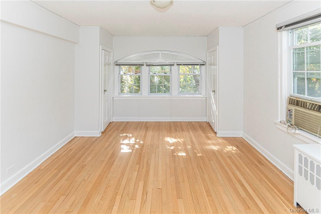 270 Bronxville Road, Unit B63 Bronxville, NY 10708 - Photo 17 of 25 an empty room with wooden floor and windows