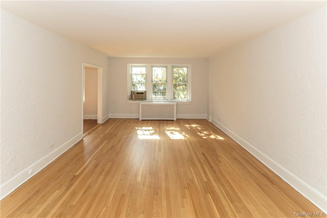270 Bronxville Road, Unit B63 Bronxville, NY 10708 - Photo 8 of 25 an empty room with wooden floor and windows