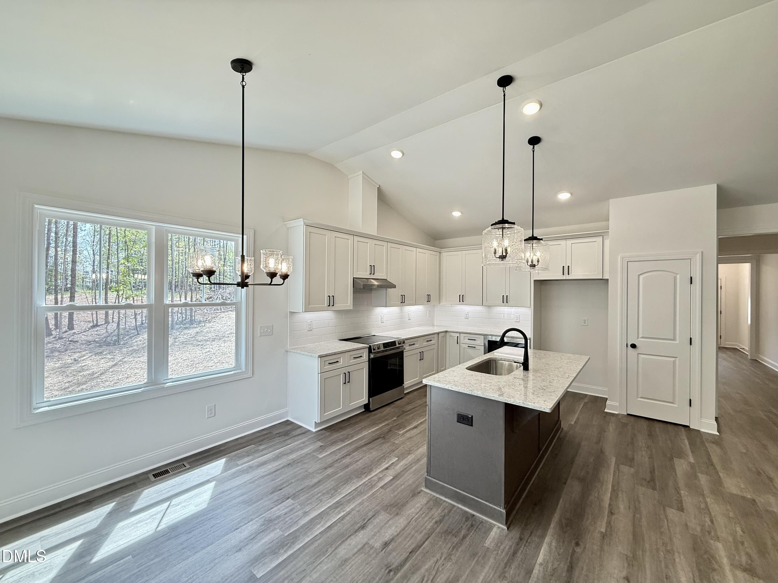 10300 Stallings Road Spring Hope, NC 27882 - Photo 14 of 36 a large kitchen with stainless steel appliances a large counter top a sink a window and wooden floor