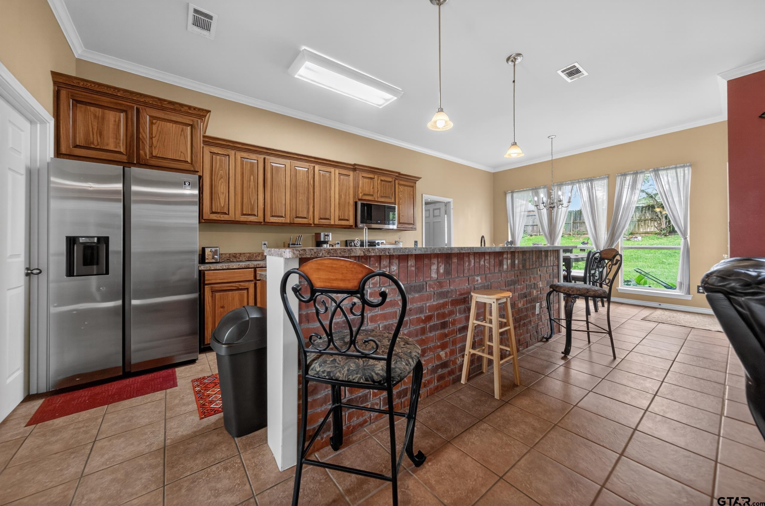 11274 Meadows Drive Flint, TX 75762 - Photo 13 of 43 a kitchen with stainless steel appliances granite countertop a refrigerator a stove a sink a dining table and chairs with wooden floor