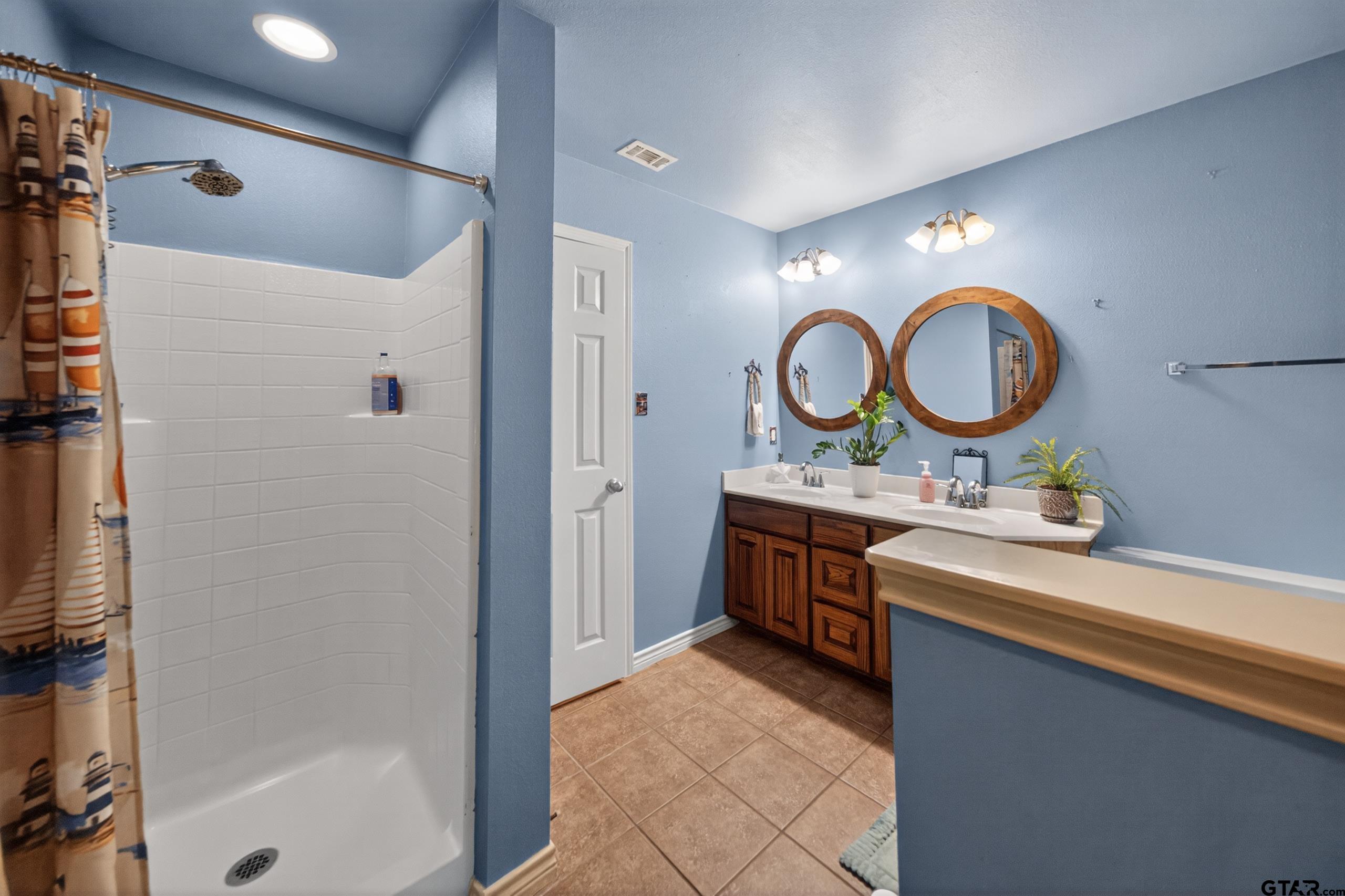 11274 Meadows Drive Flint, TX 75762 - Photo 21 of 43 a bathroom with a double vanity sink and a mirror