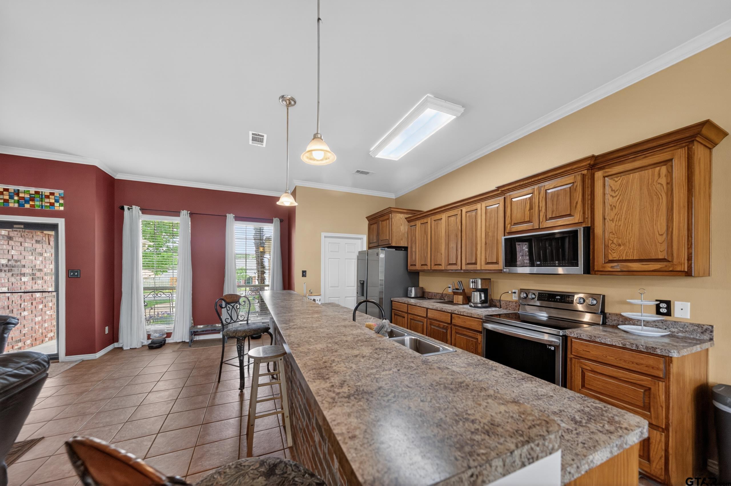 11274 Meadows Drive Flint, TX 75762 - Photo 7 of 43 a large kitchen with kitchen island granite countertop a stove top oven a sink a counter space and cabinets