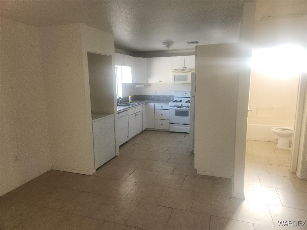 352 Rio Grande Court Bullhead City, AZ 86442 - Photo 5 of 14 a kitchen with a refrigerator and white cabinets