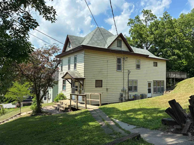 a view of a house with a yard patio and a garden