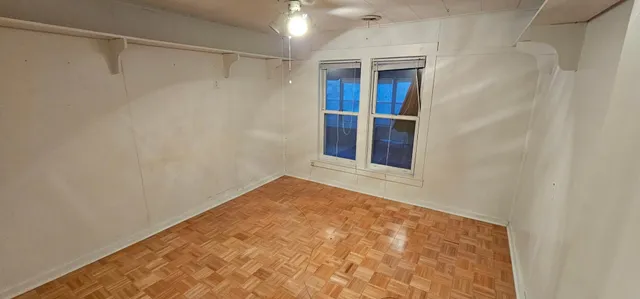 a view of empty room with wooden floor and fireplace