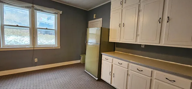 an empty room with wooden floor fan and window