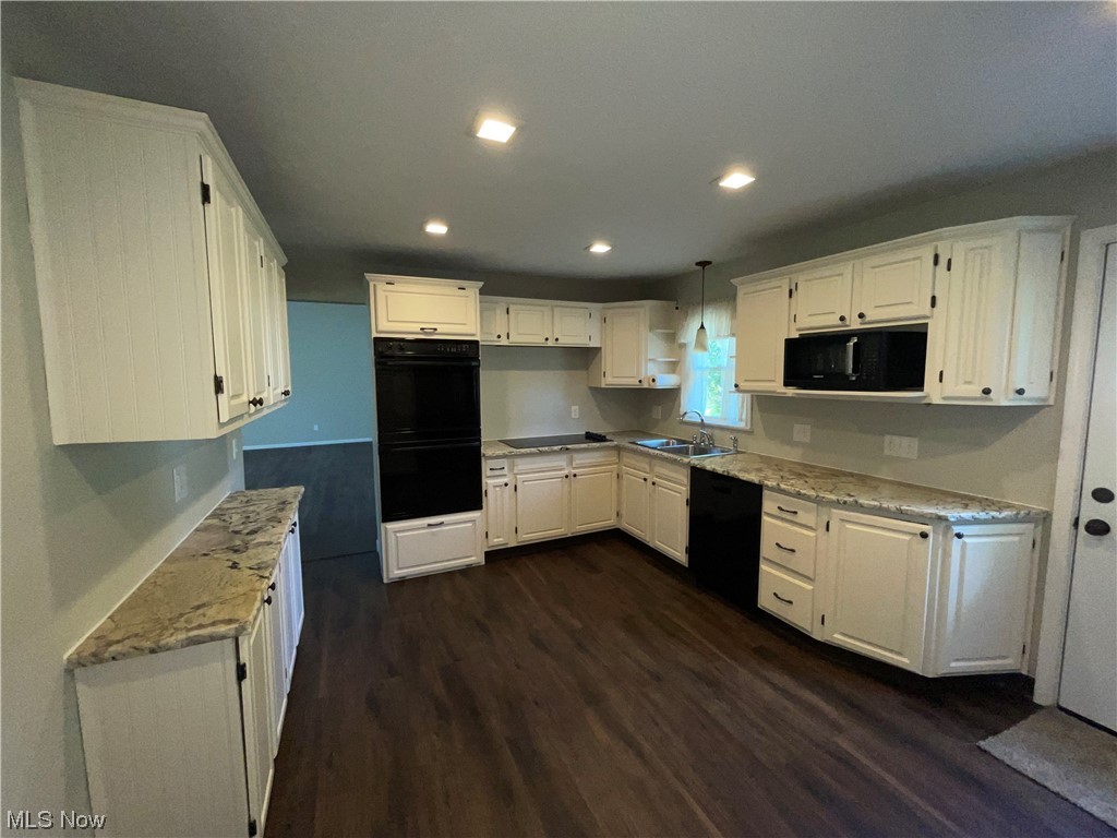 7114 Risden Road Vermilion, OH 44089 - Photo 17 of 35 Kitchen featuring dark hardwood flooring, black appliances, light countertops, and white cabinetry