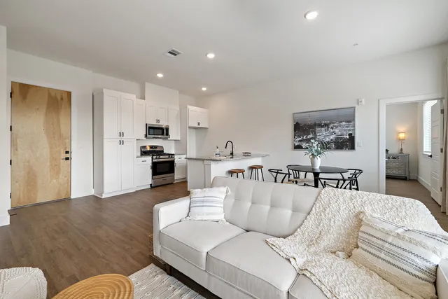 a living room with furniture and kitchen view