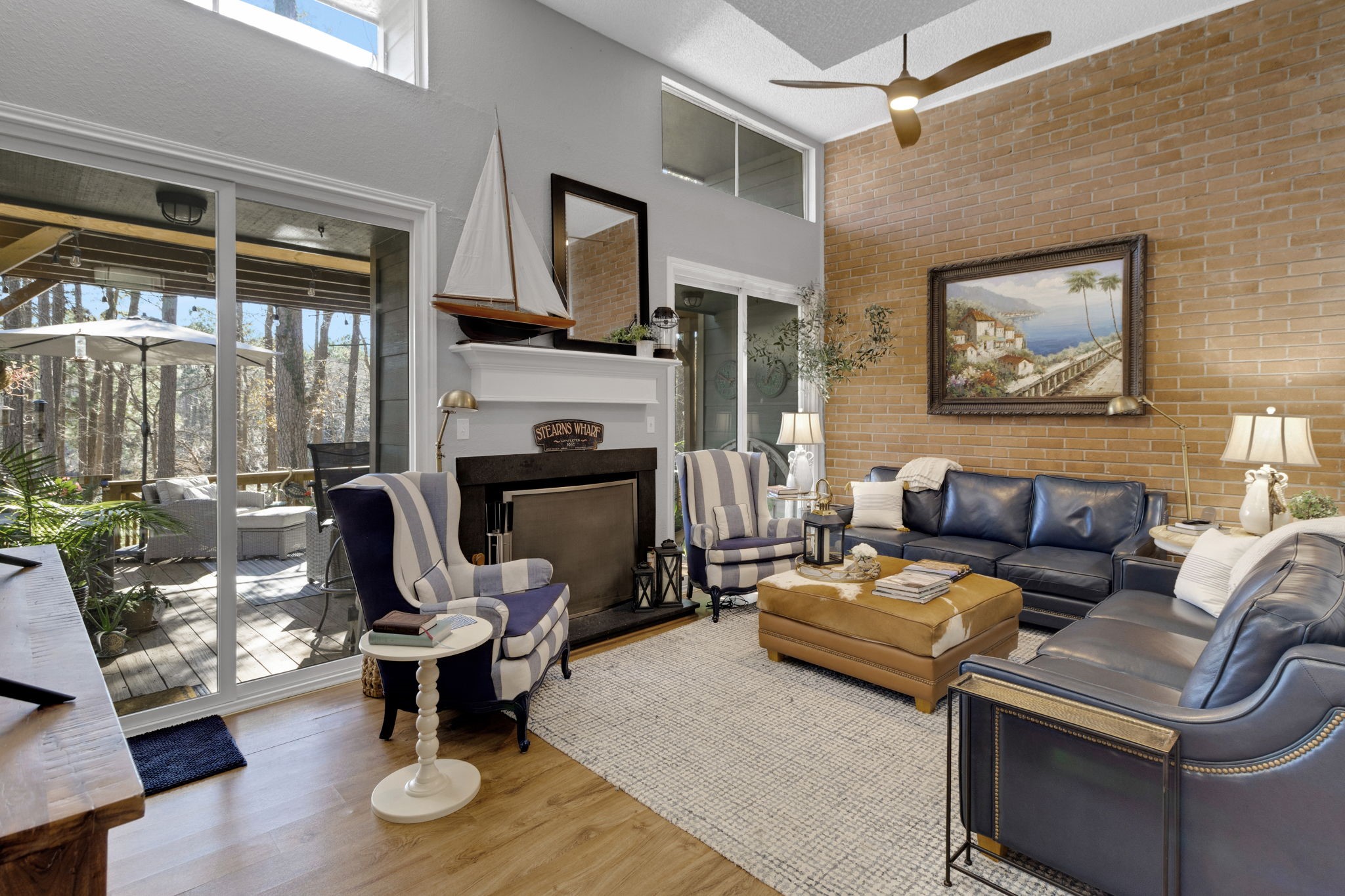 154 Villa Way Coldspring, TX 77331 - Photo 4 of 42 Flow through to the living area with high ceilings, LVP flooring, wood burning fireplace and updated sliding doors leading to the back deck