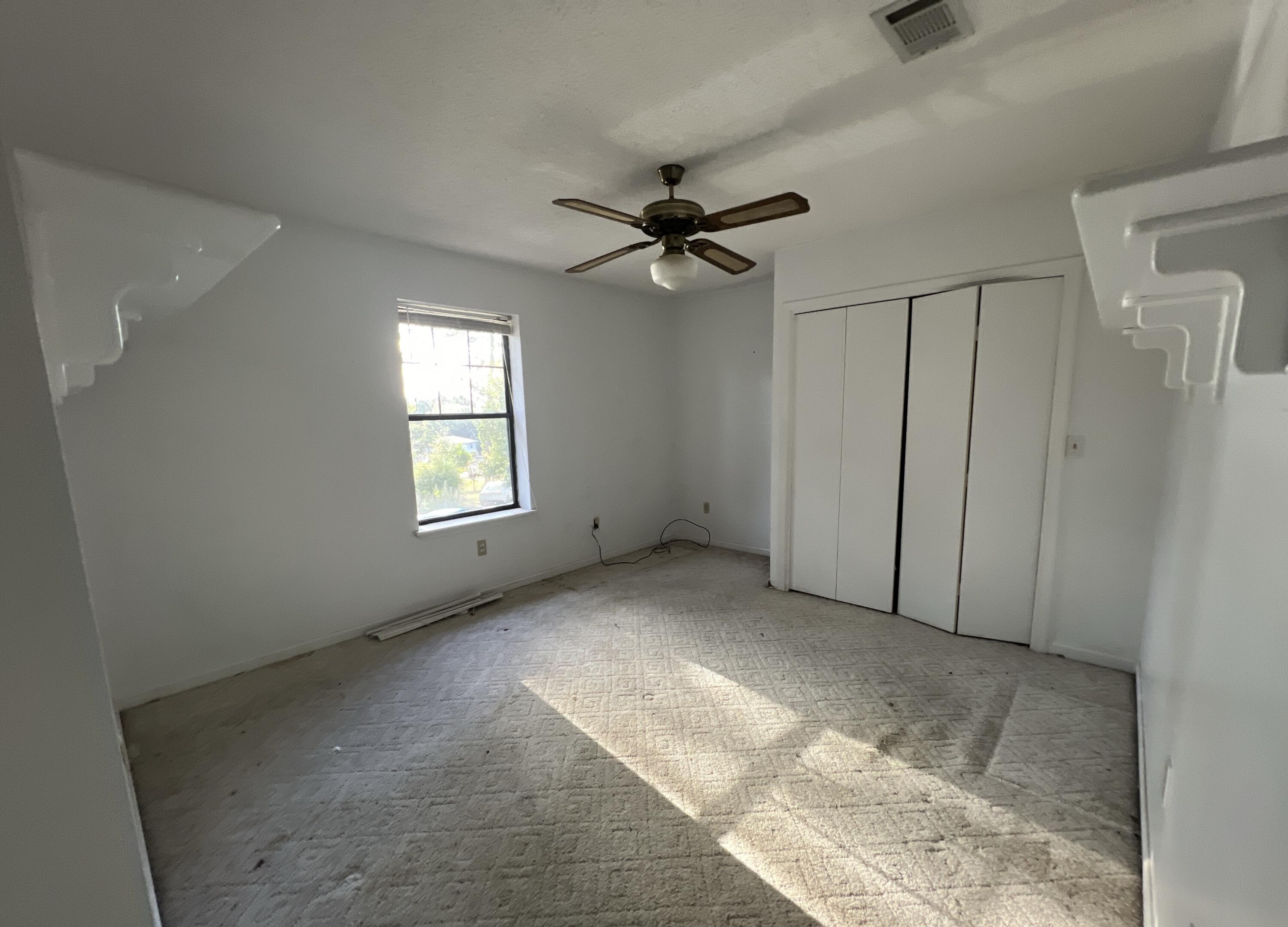 4746 Pebble Creek Drive Pensacola, FL 32526 - Photo 22 of 23 an empty room with windows and fan