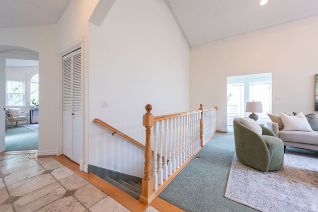 875 East 1300th Street North Mapleton, UT 84664 - Photo 13 of 65 Hallway with an upstairs landing, light stone finish floors, arched walkways, recessed lighting, and vaulted ceiling