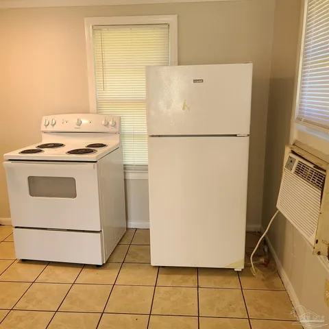 a white refrigerator freezer and a stove sitting inside of a kitchen