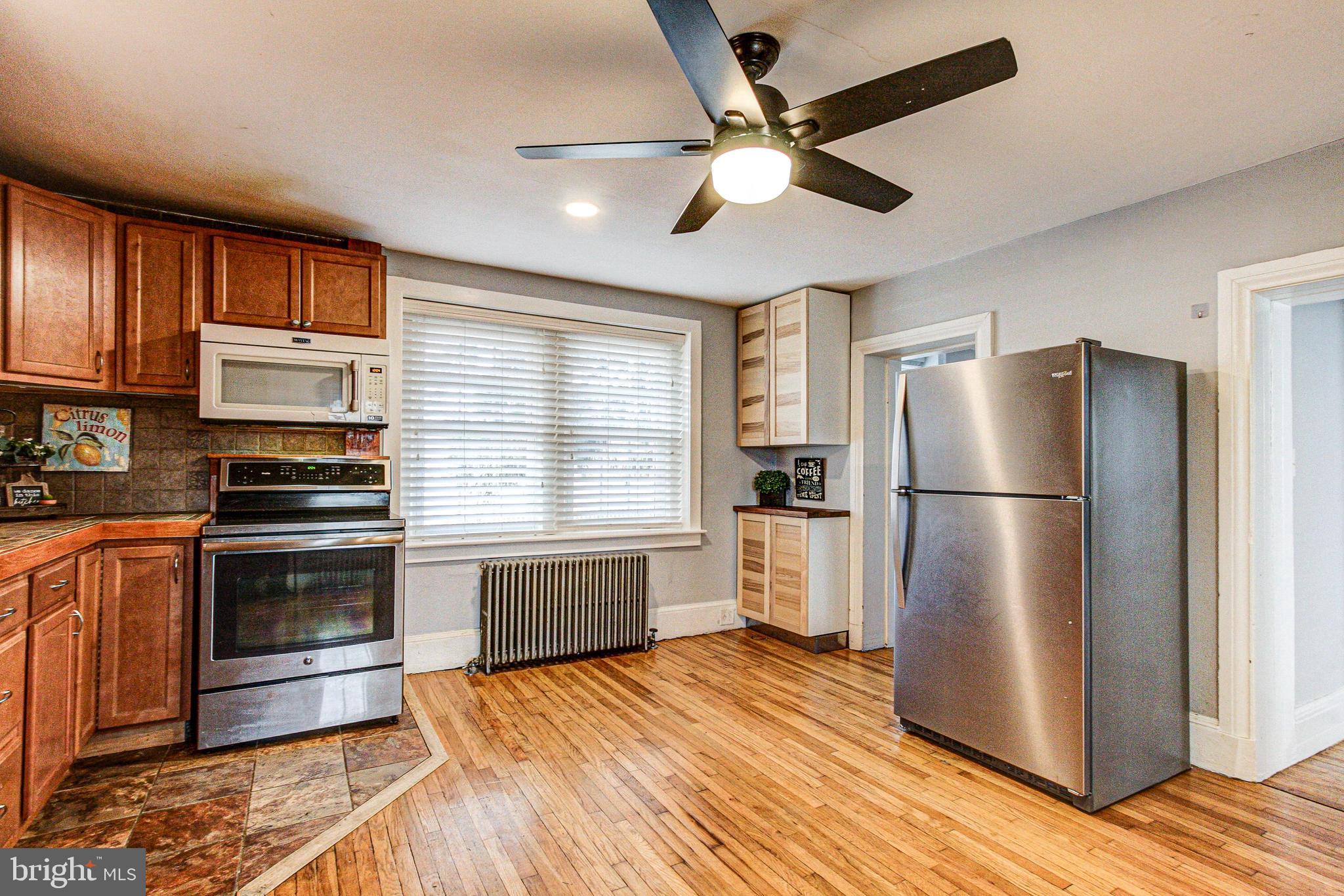 1079 Old Skippack Road Harleysville, PA 19438 - Photo 16 of 53 a kitchen with stainless steel appliances wooden floor sink and wooden cabinets