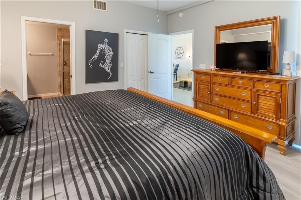 8065 Tiger Cove, Unit 1604 Naples, FL 34113 - Photo 12 of 23 a bedroom with furniture and flat screen tv