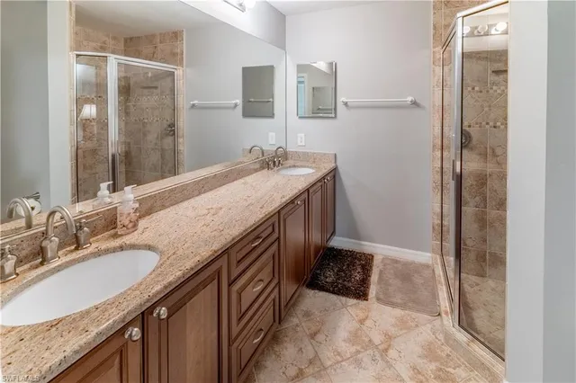 a bathroom with a granite countertop sink a mirror and a shower