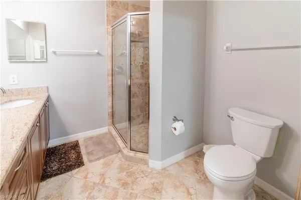 a bathroom with a granite countertop toilet and a sink