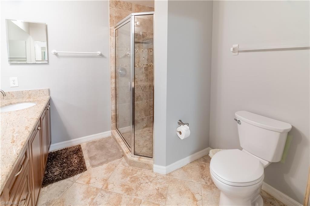 8065 Tiger Cove, Unit 1604 Naples, FL 34113 - Photo 16 of 23 a bathroom with a granite countertop toilet and a sink