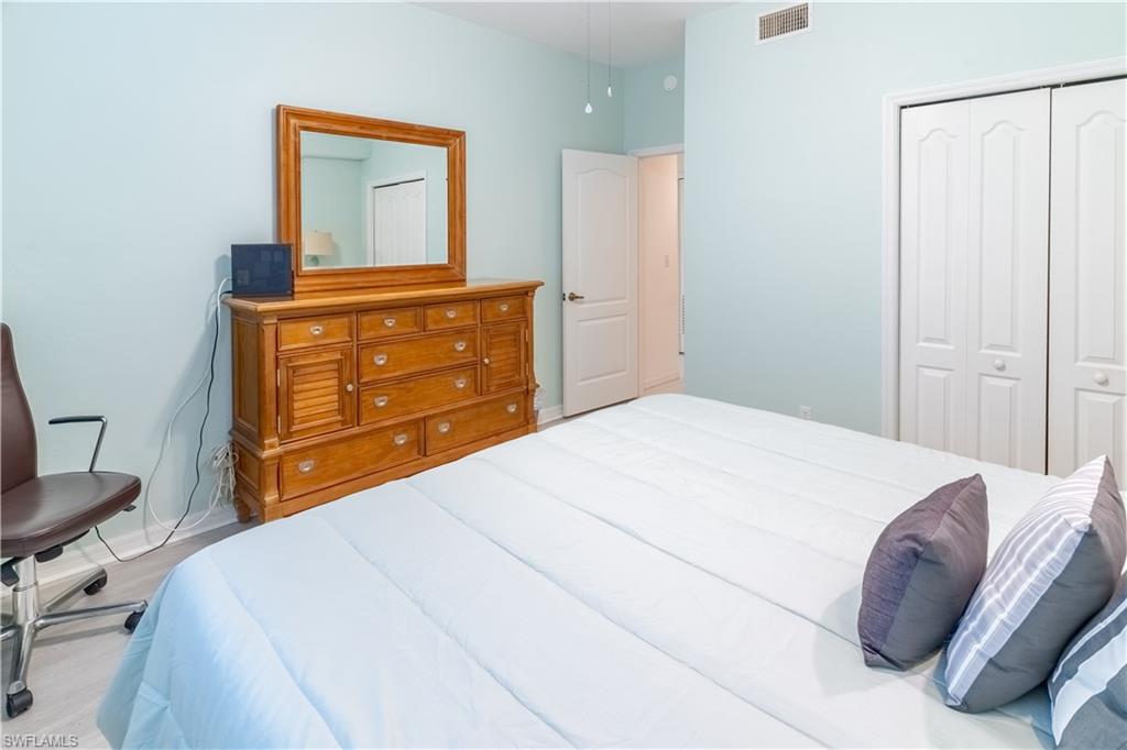 8065 Tiger Cove, Unit 1604 Naples, FL 34113 - Photo 18 of 23 a bedroom with a bed and a dresser