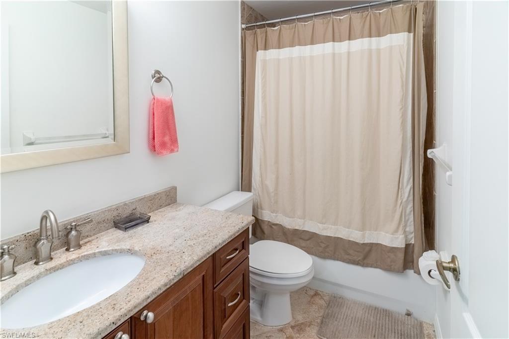 8065 Tiger Cove, Unit 1604 Naples, FL 34113 - Photo 20 of 23 a bathroom with a granite countertop sink and a mirror