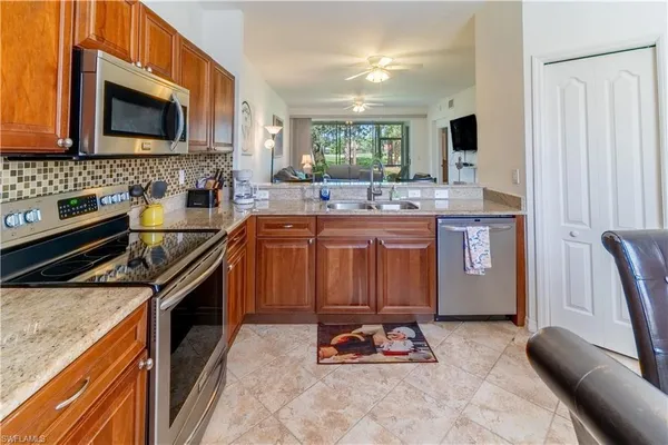 a kitchen with stainless steel appliances granite countertop a sink stove and microwave
