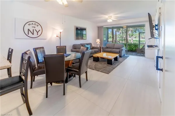 a living room with furniture a clock tv and a window