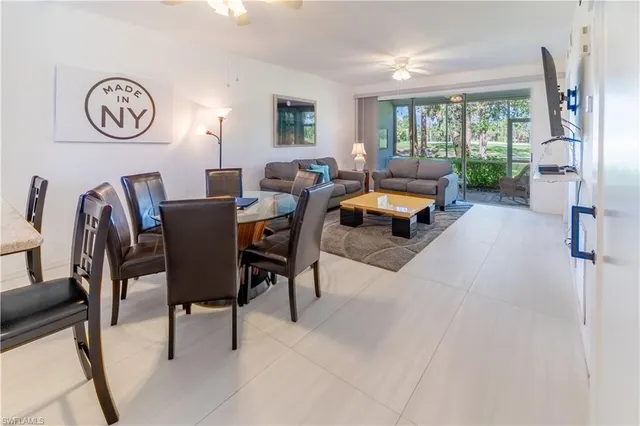 a living room with furniture a clock tv and a window