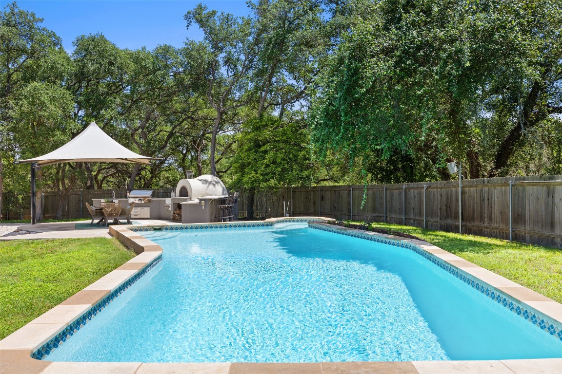 a view of a backyard with swimming pool and furniture