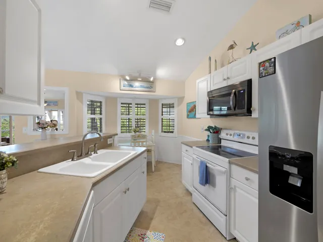 a spacious kitchen with stainless steel appliances granite countertop a sink and dishwasher a stove top oven with wooden floor