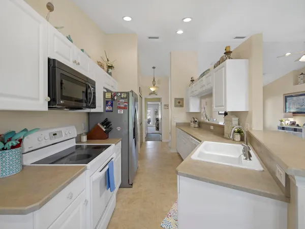 a kitchen with a sink a counter top space stainless steel appliances and cabinets