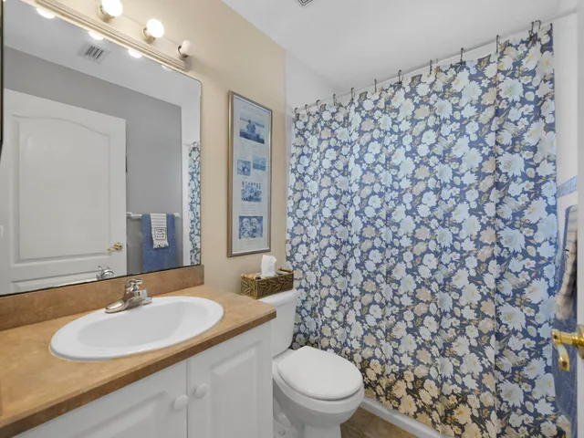 a bathroom with a granite countertop toilet and a sink