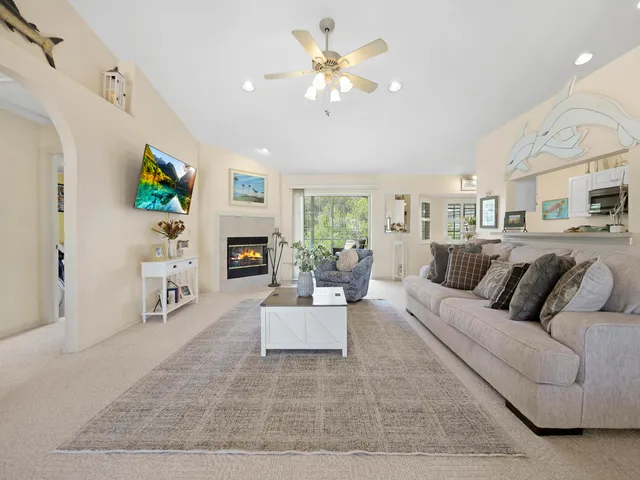 a living room with furniture a fireplace and a flat screen tv