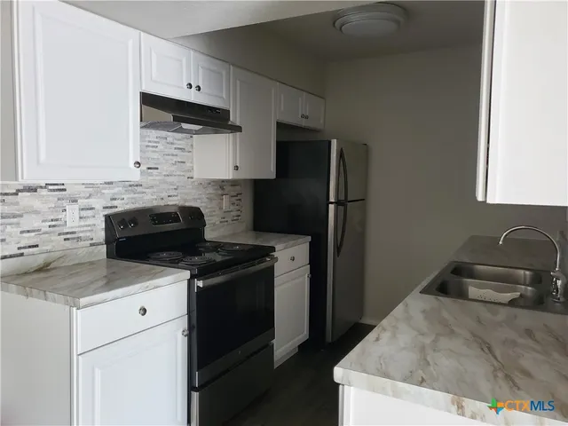 a kitchen with a sink stove and refrigerator