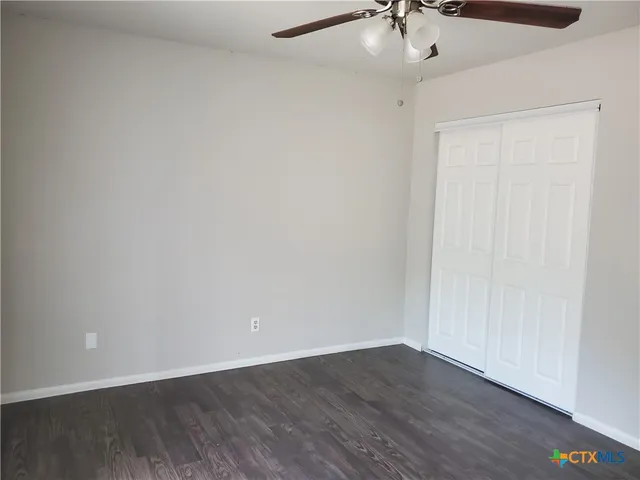 a view of an empty room with a ceiling fan