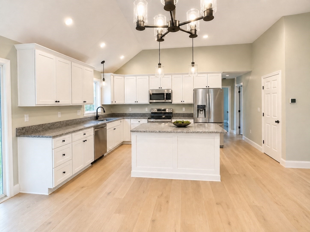 82 Pierce Street Rochester, MA 02770 - Photo 6 of 7 a large kitchen with stainless steel appliances kitchen island granite countertop a stove a sink a refrigerator and white cabinets with wooden floor