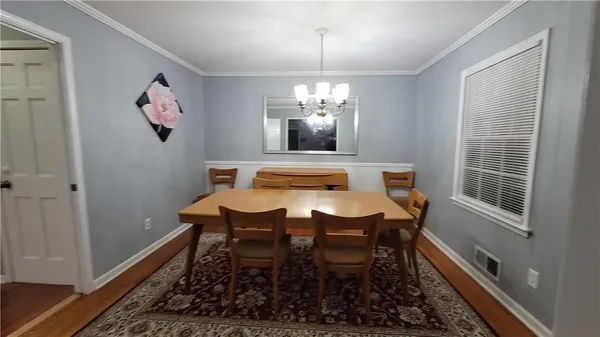 a dining room with furniture a rug and a chandelier