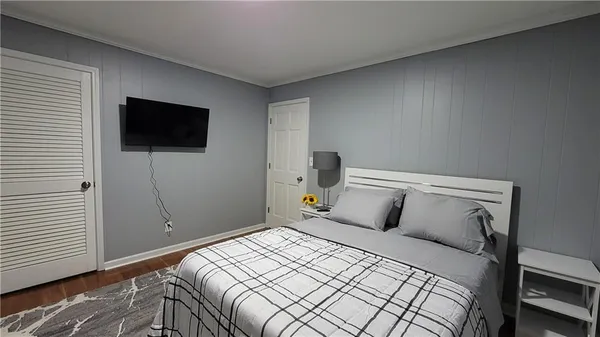 a bedroom with a bed and a flat screen tv