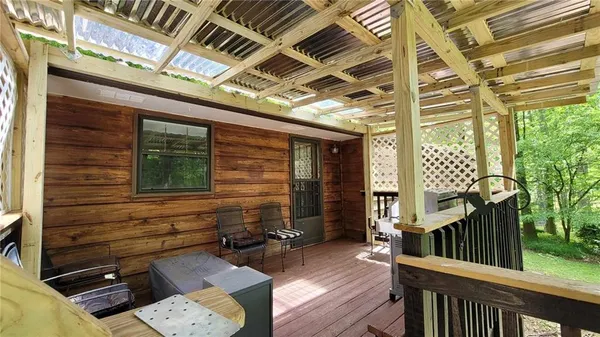 a view of backyard with wooden deck and furniture