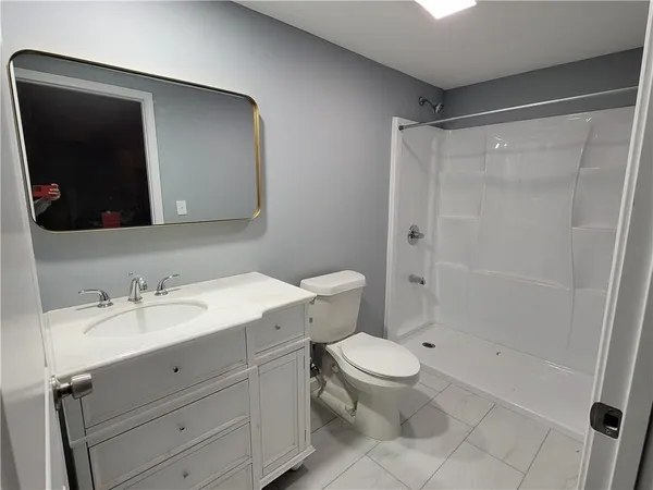 a bathroom with a sink a toilet and shower