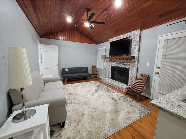 a living room with furniture a flat screen tv and a fireplace