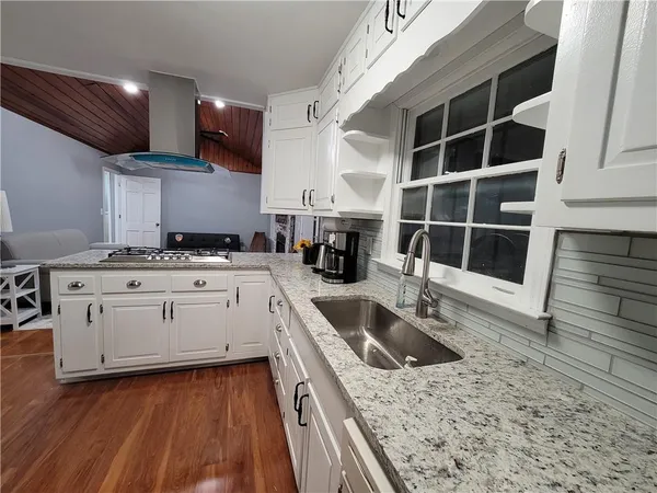 a kitchen with stainless steel appliances granite countertop a sink stove and cabinets