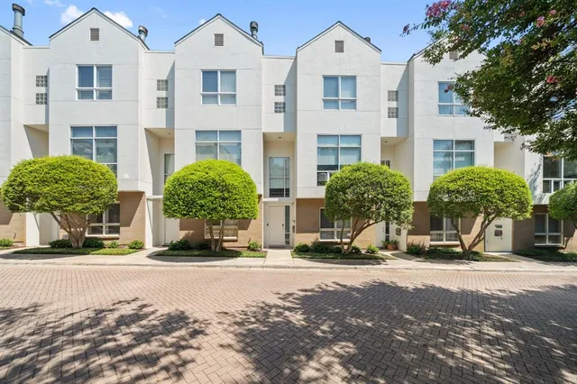 a front view of multiple houses with yard