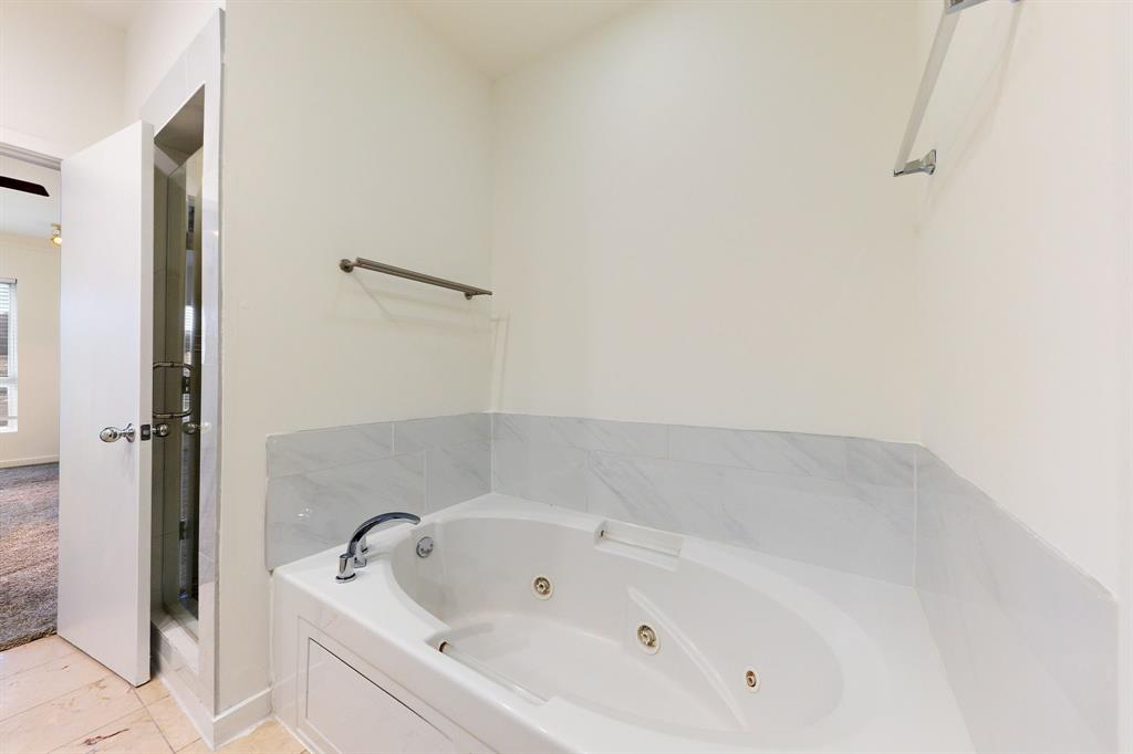 4060 Travis Street, Unit 12 Dallas, TX 75204 - Photo 15 of 20 a white bath tub sitting in a bathroom