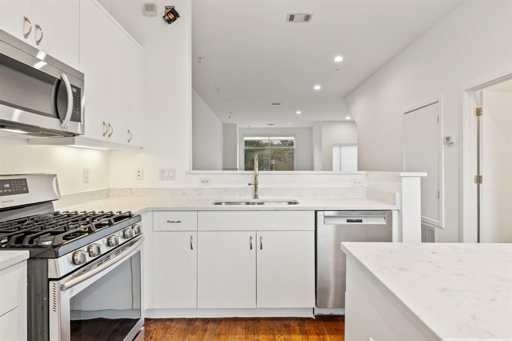 4060 Travis Street, Unit 12 Dallas, TX 75204 - Photo 5 of 20 a kitchen with a sink stove top oven and cabinets