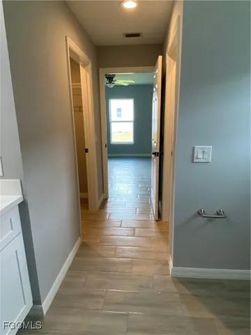 a view of a hallway with wooden floor and closet