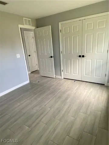 an empty room with wooden floor and entrance